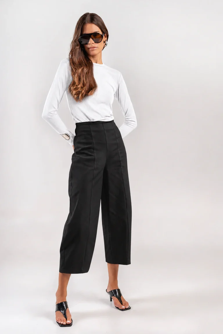 Teta Arvanitaki Adel black pants, front view showing the high waist and vertical seams, styled with a white top