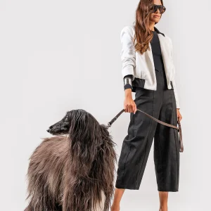 Teta Arvanitaki Character White Jacket, full-length three-quarter view with the model holding a dog on a leash.