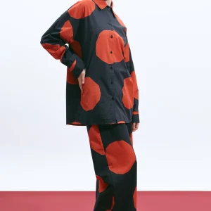 The Norm Dot wide-leg cotton poplin pants with terracotta geometric dots, styled with the matching shirt in side view