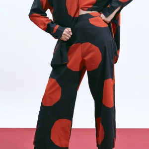 The Norm Dot cotton poplin pants, front detail showing the flat waistband and oversized terracotta dot print