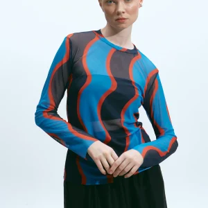 The Norm Vague Bleu mesh top with undulating blue and terracotta stripes, model with hand on hip
