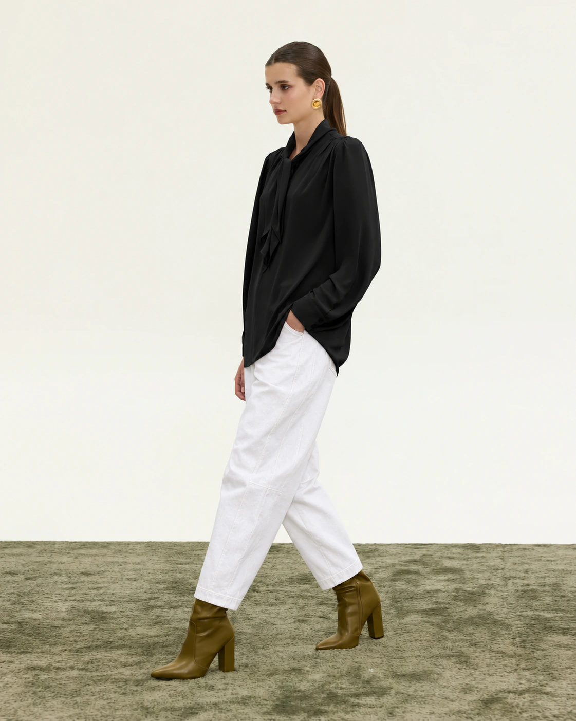 Innocent Estelle Tie-Neck Top in black on model, walking view showing neck tie and long sleeves