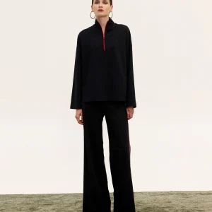Innocent Raven black top and pants on model, front view showing red zip on top and wide-leg pants