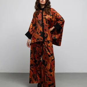 Pearl kaftan shirt by We Are with orange and red paisley print on a black base, front view with matching Midler pants