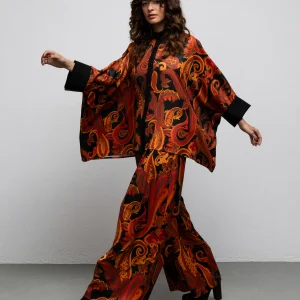 Pearl Paisley Black kaftan shirt by We Are worn with matching Midler pants, walking view with arms extended